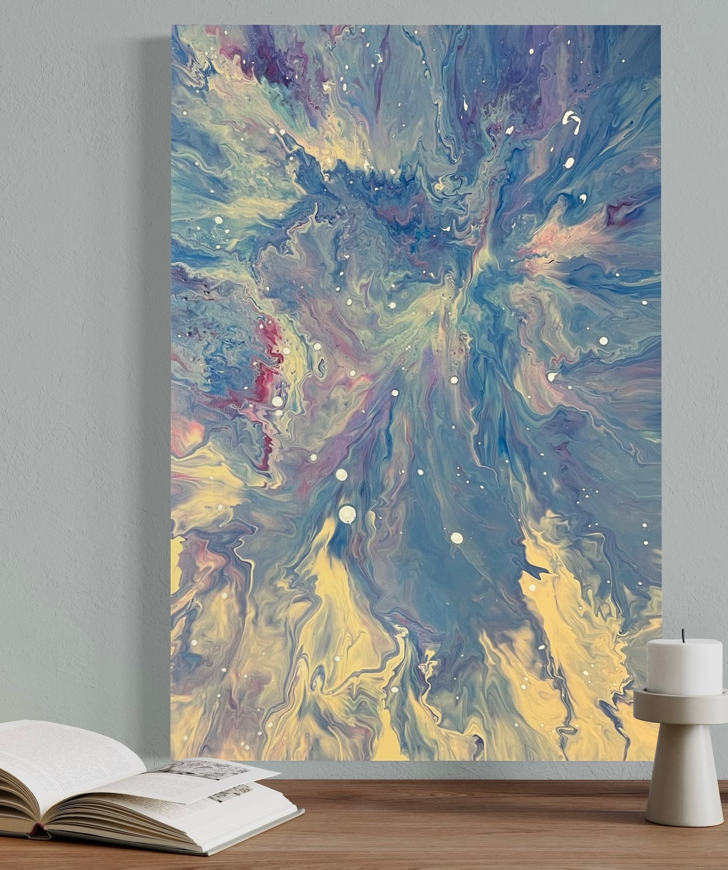 Abstract acrylic painting in blue, white and pastel tones with dynamic flow technique and white speckles - Modern fluid art artwork with galactic flair on a light background.