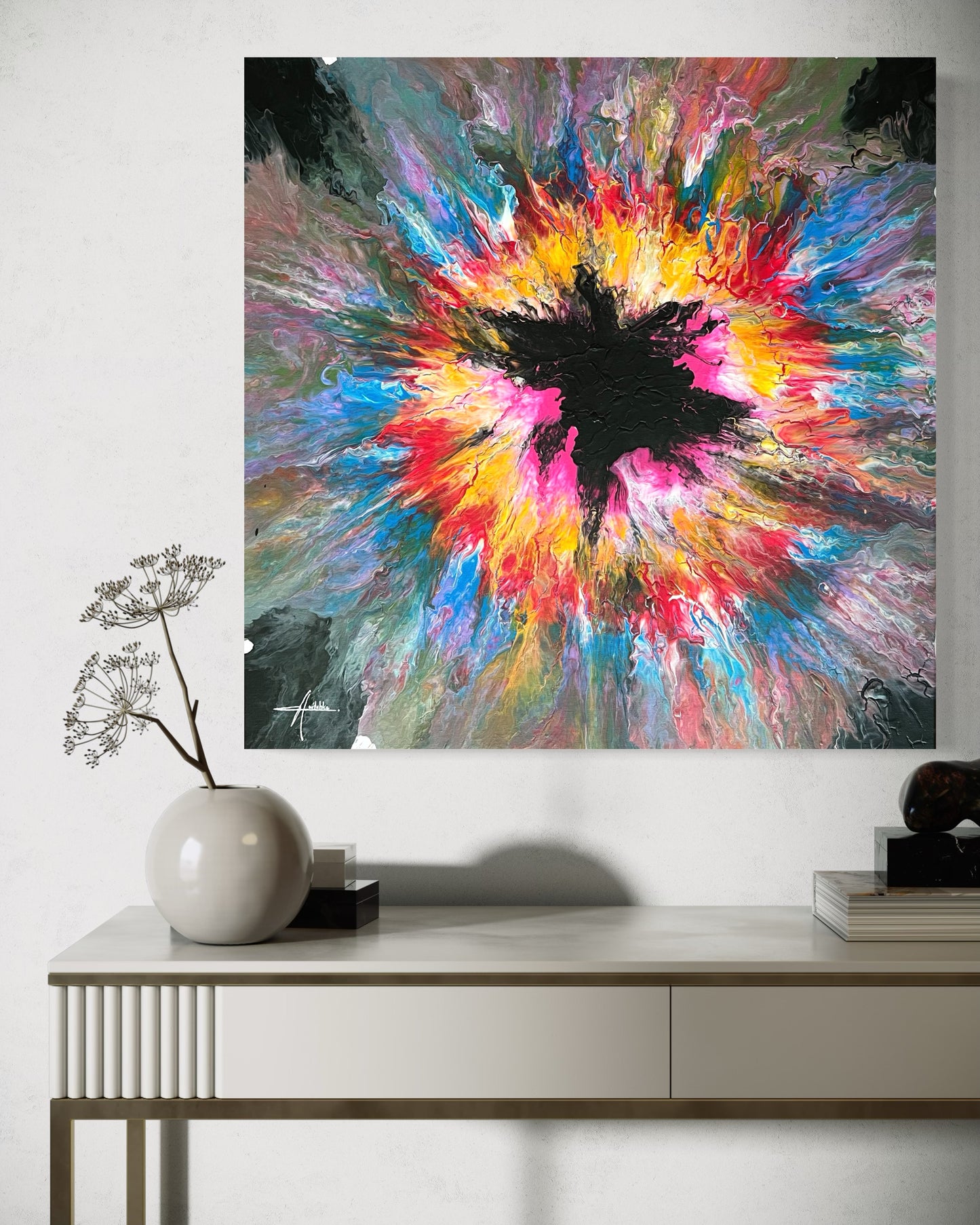 Abstract acrylic painting with an explosive burst of color in yellow, pink, blue and red on a black background - modern fluid art artwork with a central black element and powerful energy.