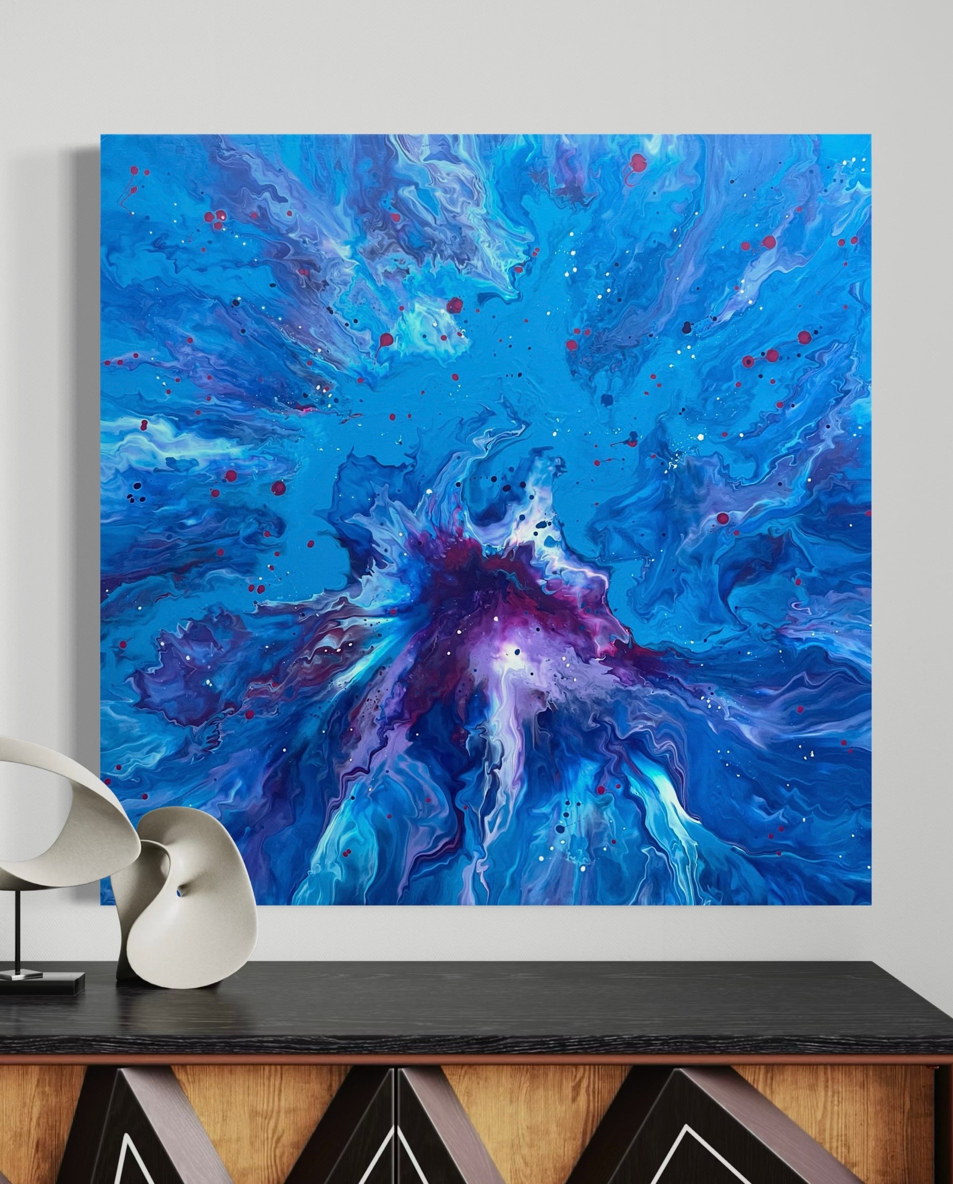 Abstract acrylic painting in intense shades of blue with a violet center, dynamic flowing structures and colorful speckles - modern fluid art artwork with a cosmic effect on a blue background.