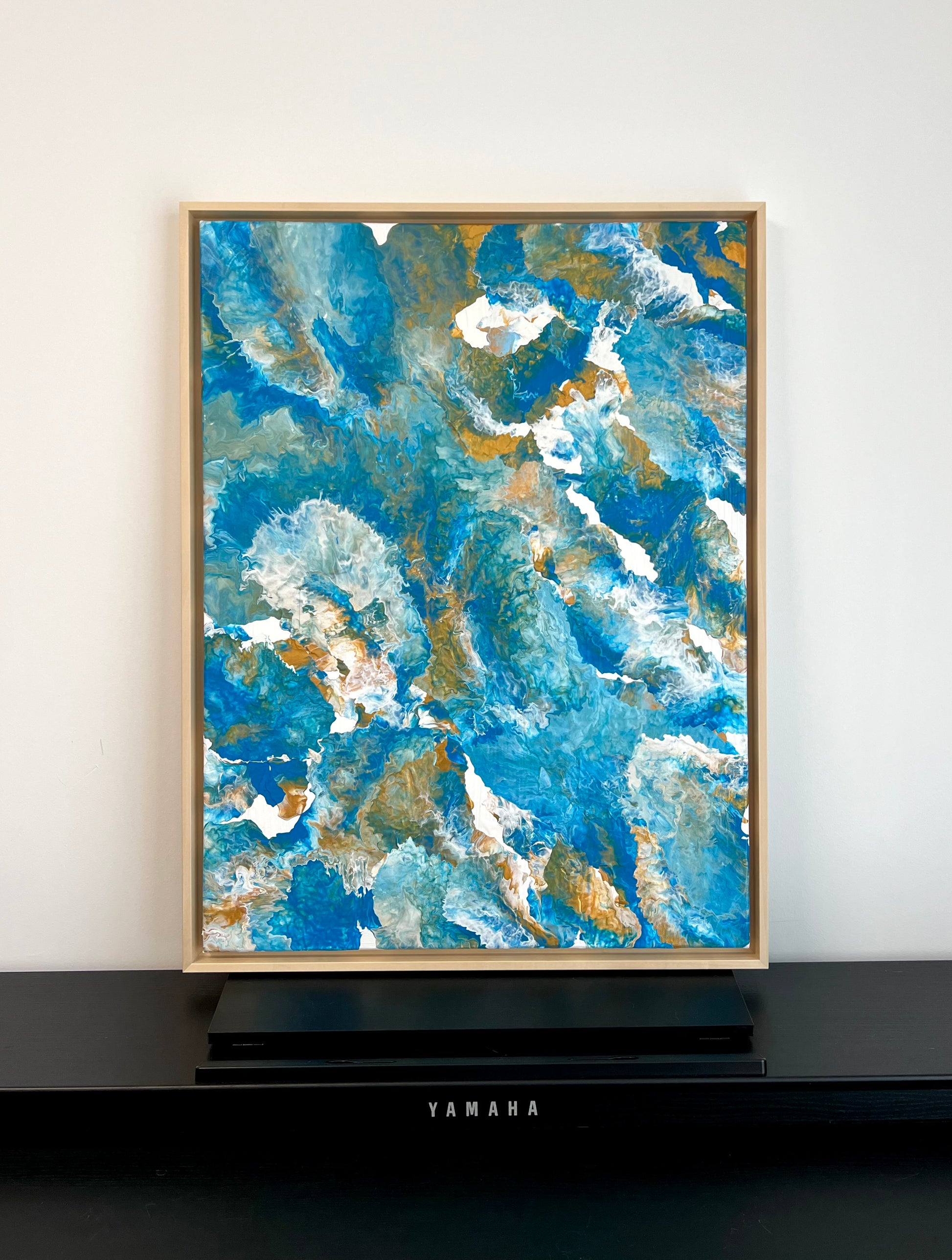 Abstract acrylic painting in shades of blue, turquoise, and gold with flowing, marbled structures. The composition is reminiscent of water, waves, or rock formations and radiates calm, depth, and natural elegance. Hand-painted, one-of-a-kind piece in the fluid art style—modern abstract art on canvas, inspired by the colors of the sea, ideal for stylish living rooms and gallery spaces.