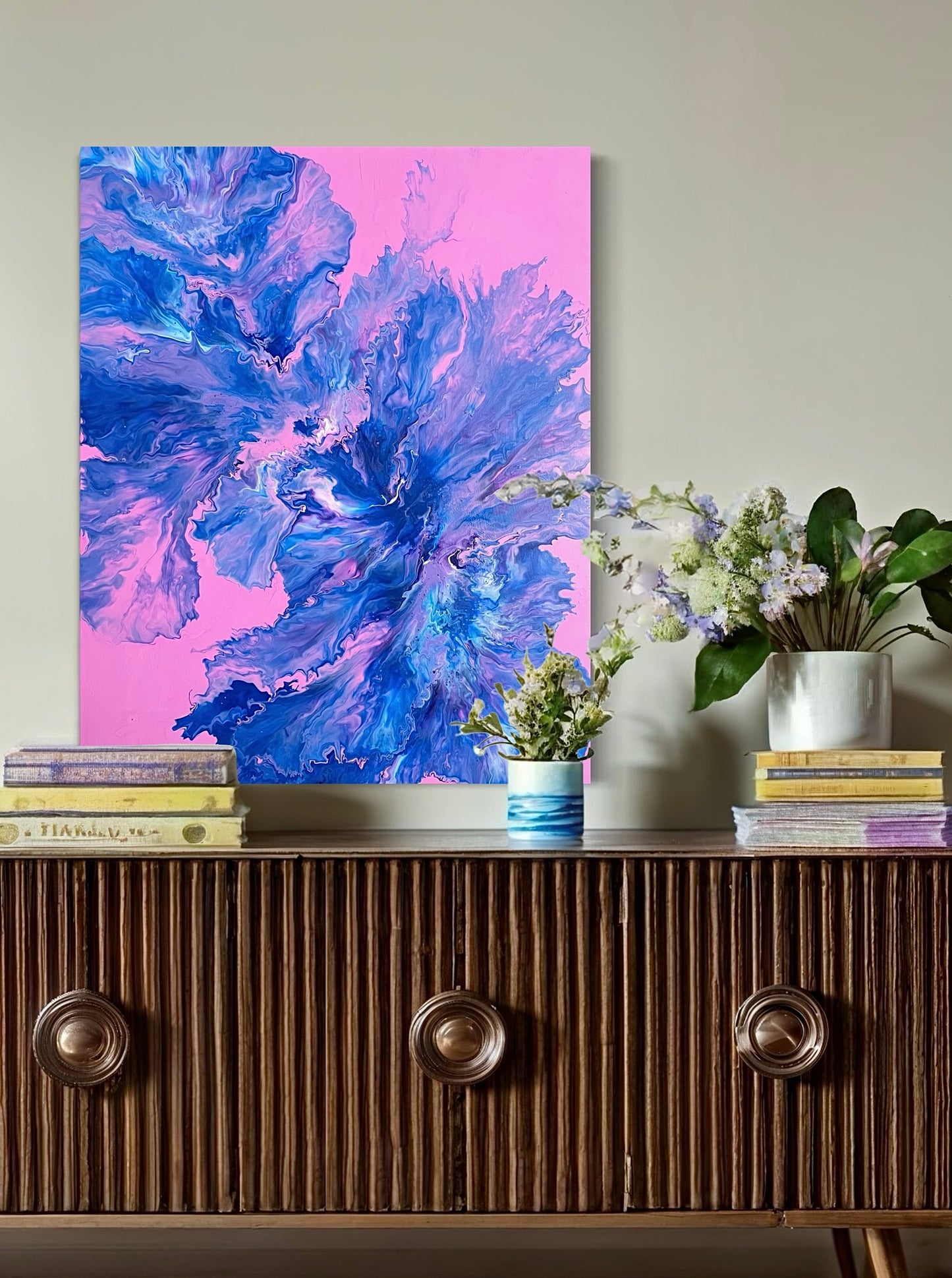 Abstract acrylic painting with vivid blue, purple and turquoise tones on a pink background - modern fluid art artwork with dynamic flowing structures for creative wall design.