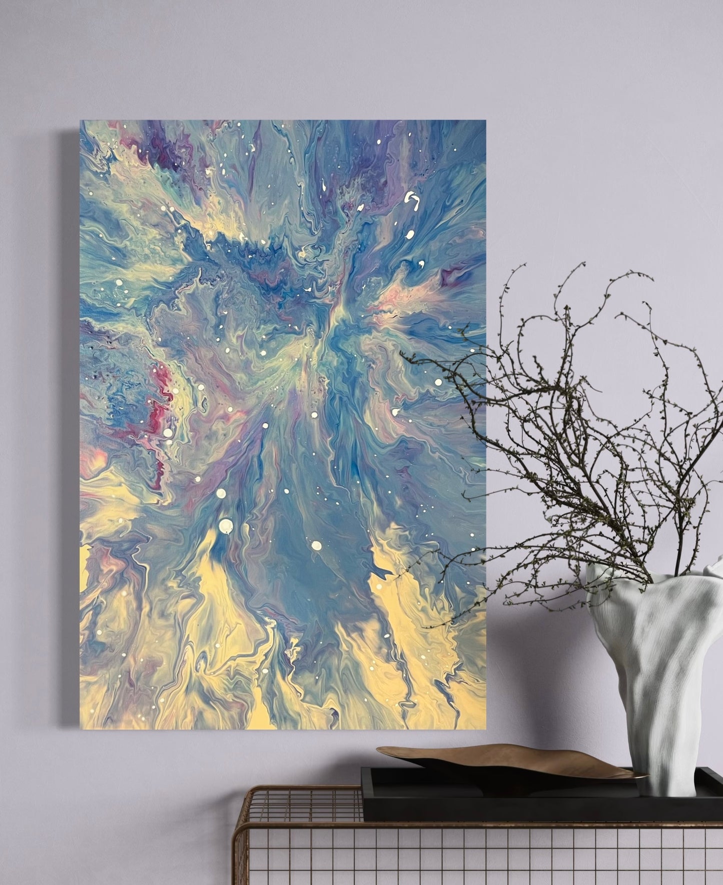 Abstract acrylic painting in blue, white and pastel tones with dynamic flow technique and white speckles - Modern fluid art artwork with galactic flair on a light background.