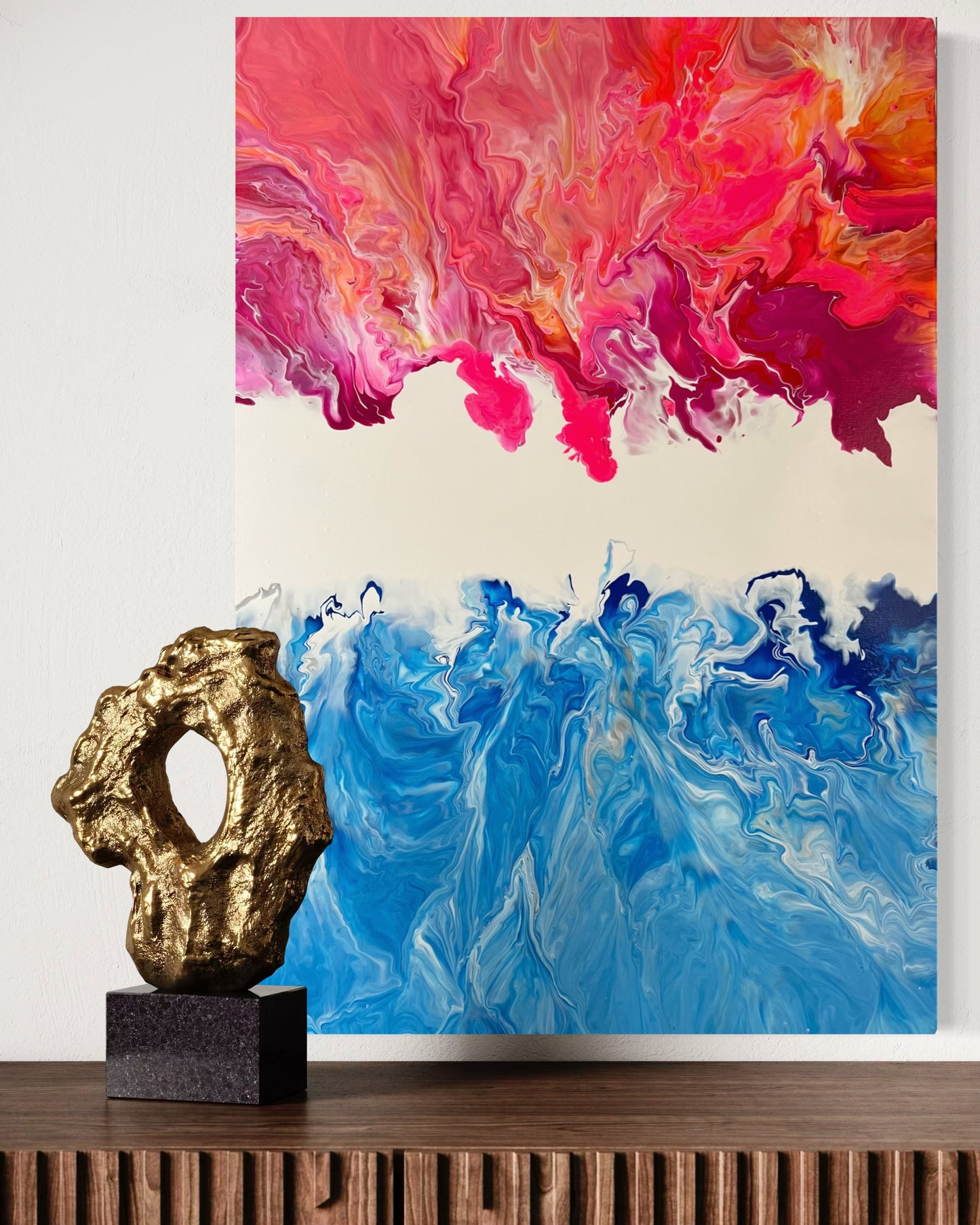 Abstract acrylic painting in vibrant shades of blue, pink, and orange, combining the dynamism of fire and water in flowing forms. The upper half of the painting features warm, fiery color gradients, while the lower blue tones are reminiscent of waves or ocean movements. Hand-painted, one-of-a-kind piece in the fluid art style—modern abstract art on canvas with strong expressiveness and harmonious color contrast, ideal as an eye-catcher in contemporary spaces.